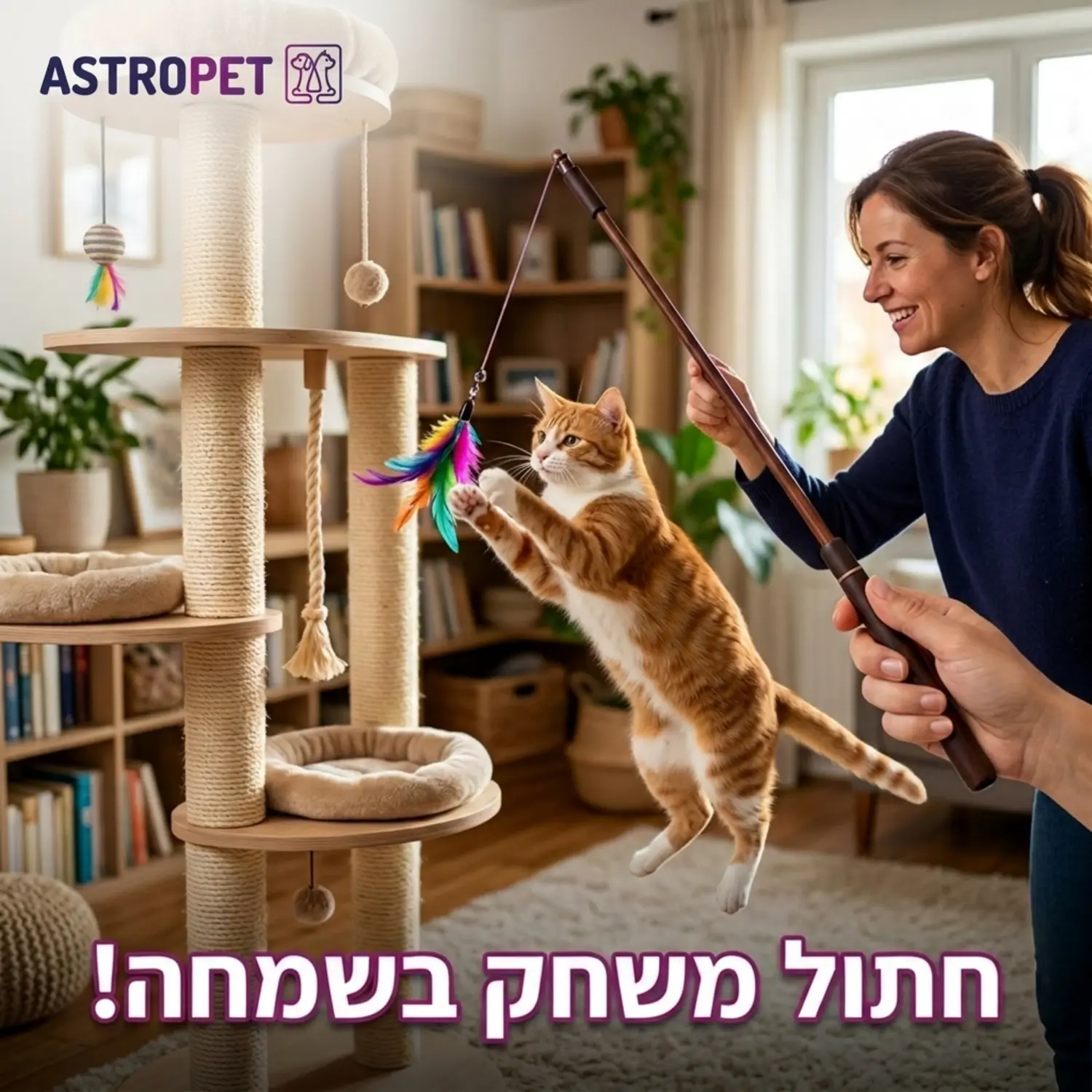 תמונה של חתול משחק בשמחה עם צעצוע חכה המופעל על ידי הבעלים שלו ליד מתקן גירוד גבוה מעץ